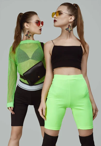 Дві елегантні гламурні дівчата-близнюки в модних неонових зелених сукнях — стокове фото