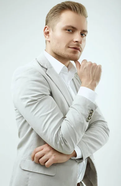 Handsome blonde man model in a fashion gray suit in studio — Stock Photo, Image