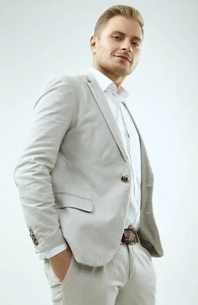 Schöner blonder Mann Modell in einem modischen grauen Anzug im Studio — Stockfoto