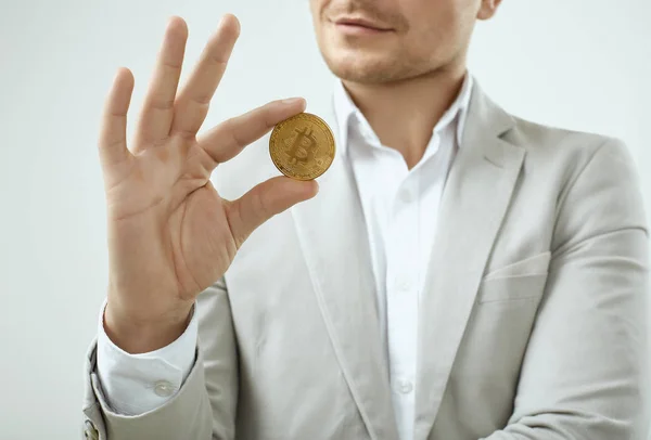 Bonito homem modelo em um terno cinza moda detém um Bitcoin — Fotografia de Stock