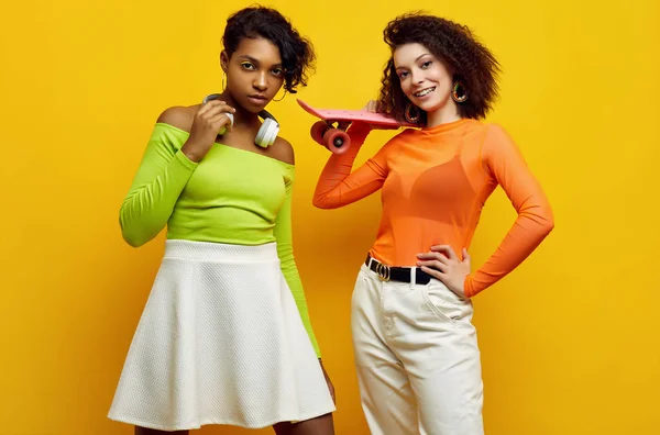 Két fiatal, gyönyörű hipster lány divatos, színes nyári ruhában. — Stock Fotó