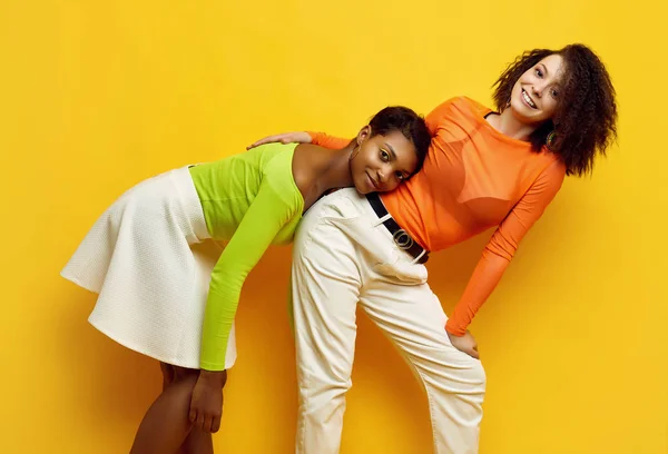 Két fiatal, gyönyörű hipster lány divatos, színes nyári ruhában. — Stock Fotó