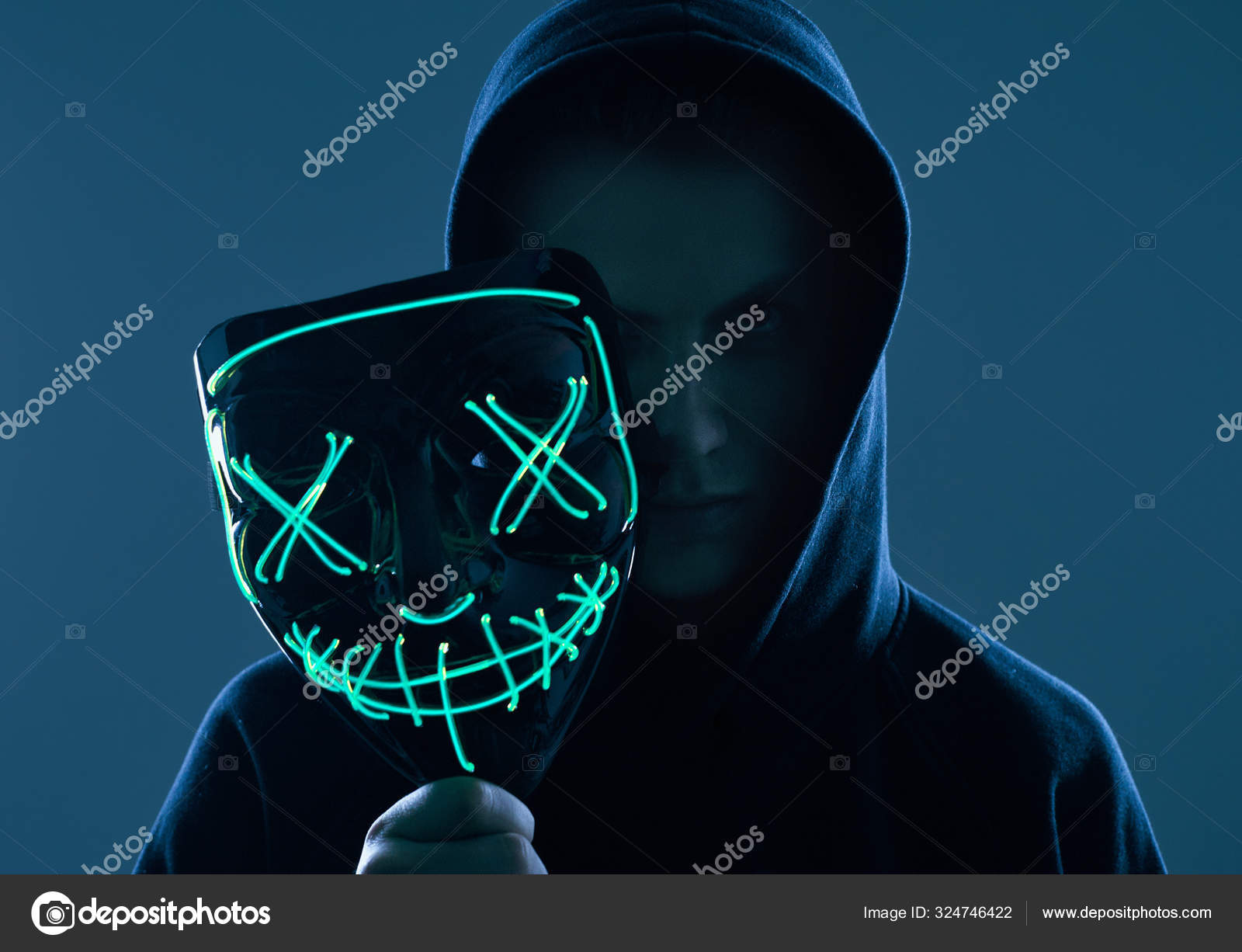 Anonymous man in black hiding face behind a mask Stock Photo by 324746422