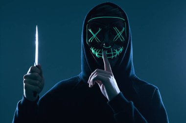 Siyah kapüşonlu ve neon maskeli kimliği belirsiz bir suçlu.