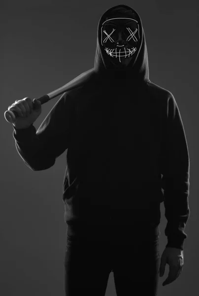 Hombre criminal anónimo con bate de béisbol en una sudadera con capucha negra y n — Foto de Stock