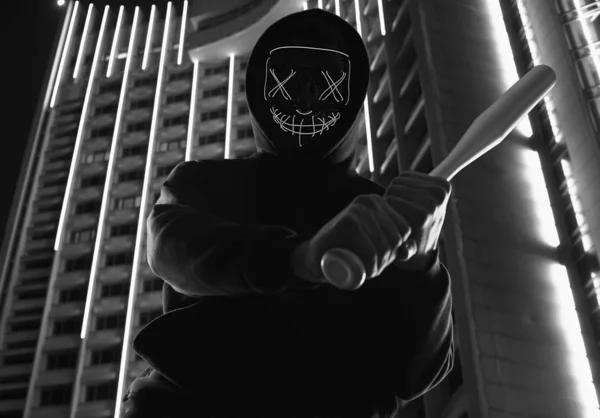 Hombre criminal anónimo con bate de béisbol en una sudadera con capucha negra y n — Foto de Stock