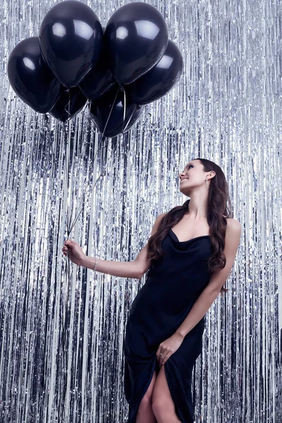 Élégante femme brune hispanique en robe noire luxueuse tient des ballons — Photo