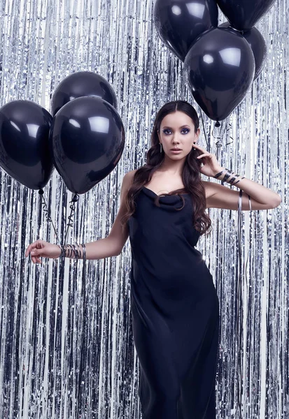 Elegante morena hispana en lujoso vestido negro sostiene globos —  Fotos de Stock