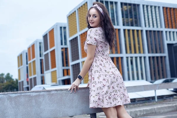 Jovem bela menina brilhante em um vestido de verão de pé em uma ponte — Fotografia de Stock