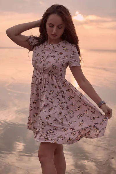 Joven hermosa chica brillante en un vestido de verano caminando en la puesta del sol — Foto de Stock