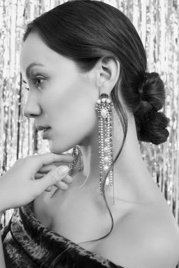 Göz kamaştırıcı, zarif, esmer latin kadının portresi. Moda yeşili elbise giymiş, parlak, süslü arka planda poz veriyor.