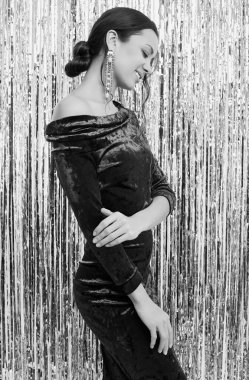 Göz kamaştırıcı, zarif, esmer latin kadının portresi. Moda yeşili elbise giymiş, parlak, süslü arka planda poz veriyor.