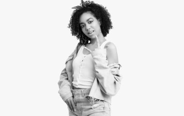 Beyaz stüdyo arka planında izole edilmiş kıvırcık saçlı, zarif siyah hippi kız modelinin şehvetli portresi.