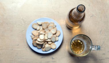 Tabakta Rusks, bir bira bardağı ve masanın üstünde elma şarabı olan bir şişe. Yumuşak odak kavramı.