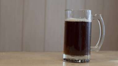 Masanın üzerinde fotokopi alanı olan bir bardak koyu bira.