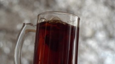 Elma parçalarını cam bardak içinde koyu elma şarabı..