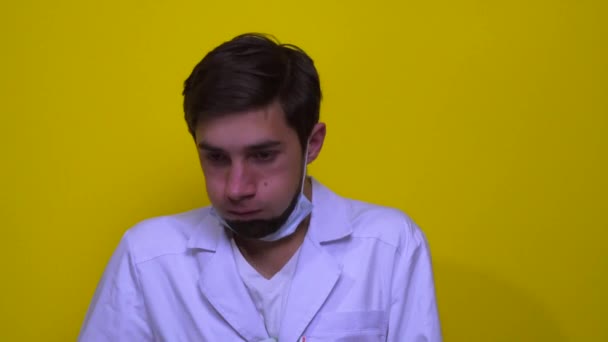 白衣を着た医者と医療マスクが咳をする 黄色の背景にコロナウイルスの概念 — ストック動画