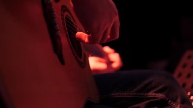 Müzisyen beyaz adam sahnede güzel akustik gitar çalar..
