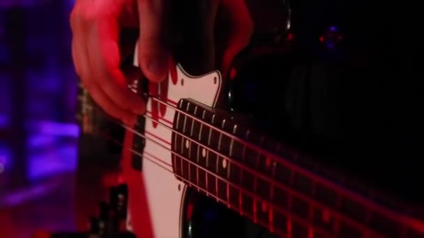 Bass guitarrista en un traje clásico toca la guitarra de bajo nivel. — Vídeo de stock