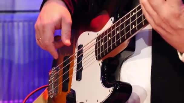 Μπάσο κιθαρίστας σε ένα κλασικό κοστούμι παίζει μπάσο κιθάρα — Αρχείο Βίντεο