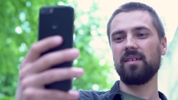 Jeune Caucasien Barbu Tient Téléphone Sur Main Parle Blogueur Communique — Video