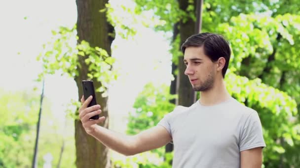 Handsome Caucasian Man Holding Phone Talking Video Blogger Broadcasts Park — Stock Video