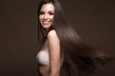 Güzel esmer kız bir mükemmel düz saç ve klasik makyaj ile hareket ettirin. Güzellik.