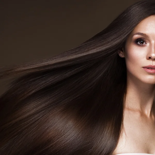 Schöne brünette Mädchen in Bewegung mit einem perfekt glatten Haar und klassischem Make-up. Schönheit Gesicht. — Stockfoto