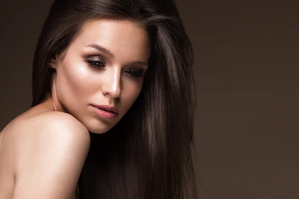 Menina morena bonita com um cabelo perfeitamente liso e maquiagem clássica. Cara de beleza . — Fotografia de Stock