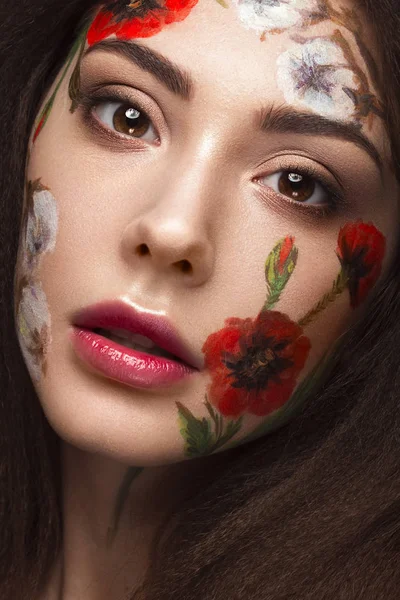 Menina morena bonita com cachos e um padrão floral no rosto. Flores de beleza . — Fotografia de Stock