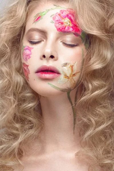 Piękna dziewczyna blond loki i kwiatowy wzór na twarzy. Piękno kwiatów. — Zdjęcie stockowe