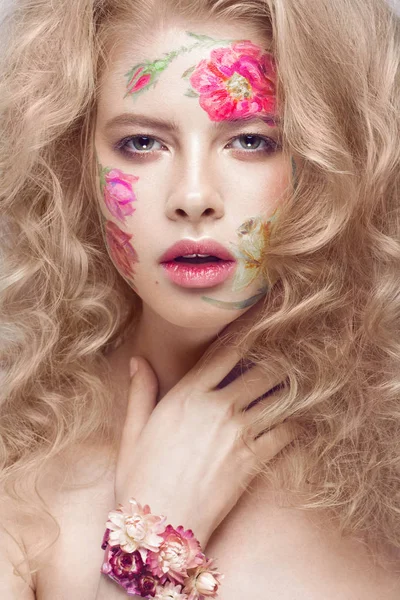 Menina loira bonita com cachos e um padrão floral no rosto. Flores de beleza . — Fotografia de Stock