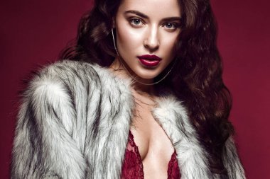 Güzel seksi uzun saçlı esmer kadın kırmızı iç çamaşırı ve kürk paltolu. Güzellik yüz, vücut.