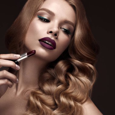 Güzel sarışın bir Hollywood şekilde bukleler, koyu dudaklar, ruj el ile. Güzellik ve saç.