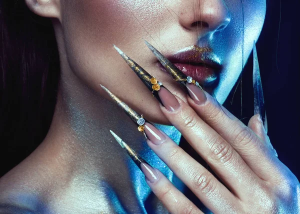 Mooi meisje met creatieve gouden en zilveren glitter make-up, lange nagels kunst. schoonheid gezicht. — Stockfoto