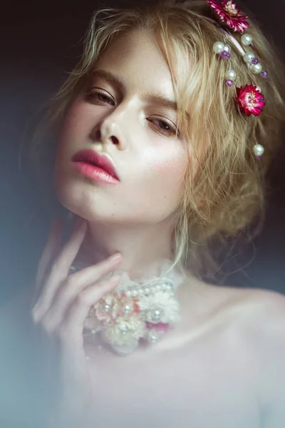 Hermosa chica rubia de moda con flores en el cuello y en el pelo, maquillaje desnudo mojado. Cara de belleza . — Foto de Stock