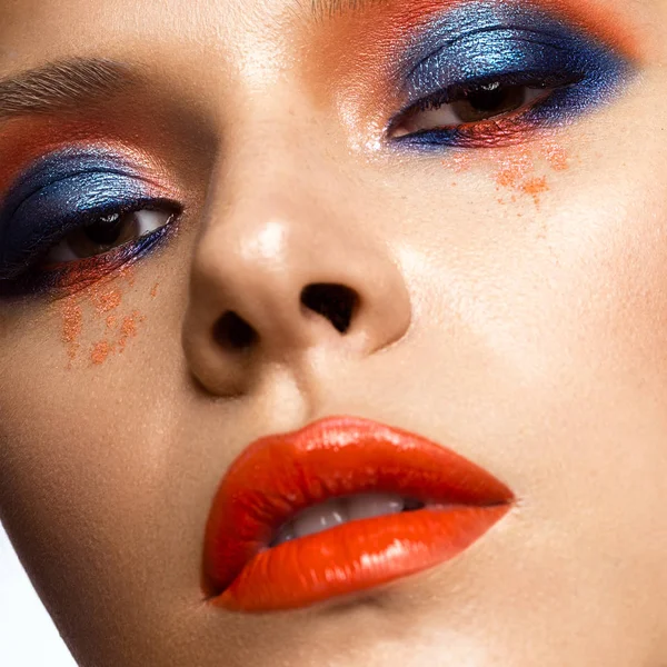 Mooi meisje met helder gekleurde make-up en oranje lippen. Schoonheid gezicht. — Stockfoto