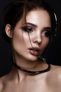 Parlak makyaj ve moda saç, dekorasyon yılan şeklinde güzel kızla. Güzellik.