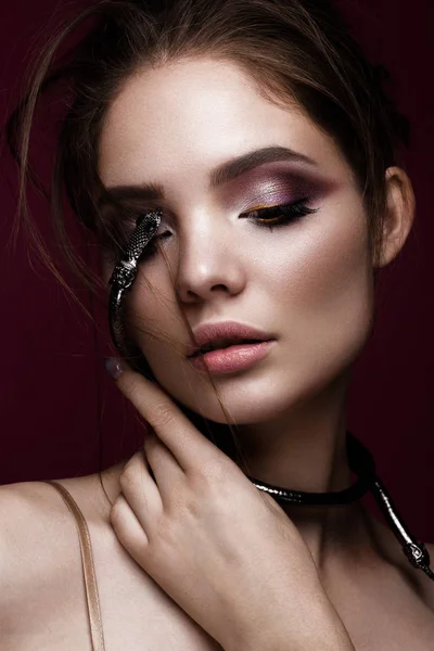 Mooi meisje met lichte make-up en modieuze haren, decoratie in de vorm van een slang. schoonheid gezicht. — Stockfoto