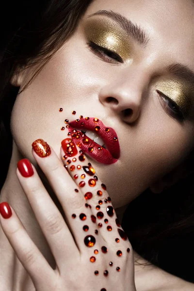 Hermosa chica con maquillaje de noche, labios rojos en pedrería y uñas de diseño de manicura. cara de belleza . — Foto de Stock