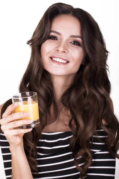 Όμορφη γυναίκα με υγιές δέρμα, μαλλιά μπούκλες και χυμό πορτοκάλι, θέτοντας στο studio. Πρόσωπο ομορφιάς. — Φωτογραφία Αρχείου