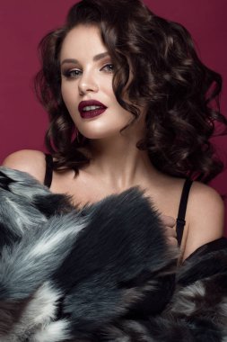 Güzel bir kadınla akşam makyaj, koyu dudaklar ve uzun saç bukleler. Dumanlı gözler. Moda fotoğraf.