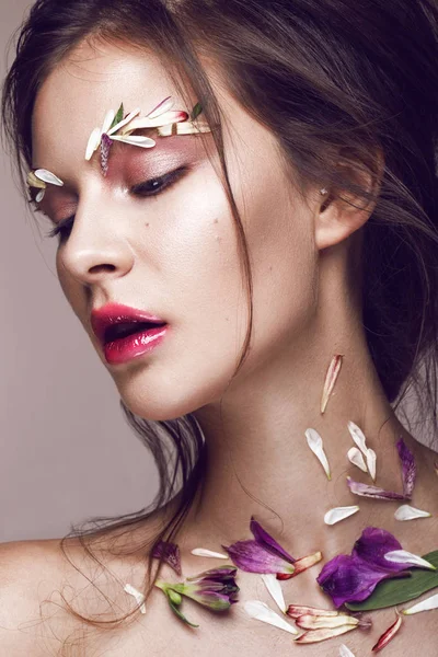 Schöne Mädchen mit Kunst Make-up und Blumen. Schönheit Gesicht. — Stockfoto