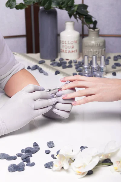 Closeup finger nail care by manicure specialist in beauty salon. — Stock Photo, Image