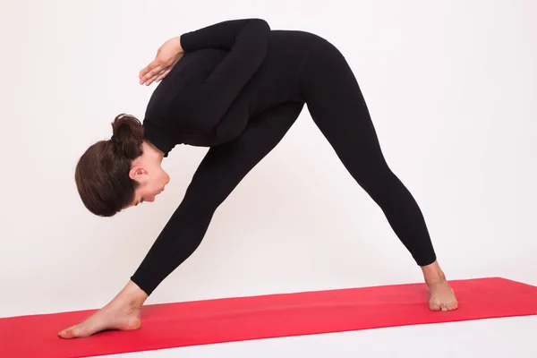 Hermosa chica atlética en traje negro haciendo asanas de yoga. Aislado sobre fondo blanco . —  Fotos de Stock