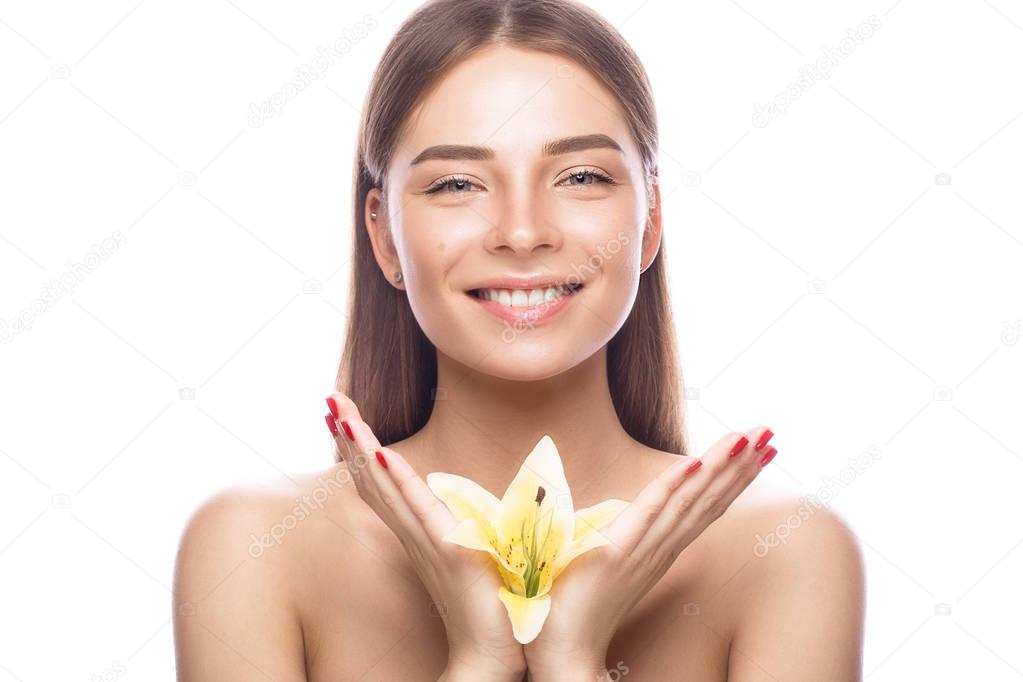 Beautiful young girl with a light natural make-up and perfect skin with flowers in her hand . Beauty face.