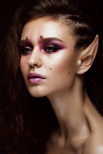 Brunett tjej med en kreativ frisyr flätor, konst make-up och elfs öron. Vackert ansikte. — Stockfoto