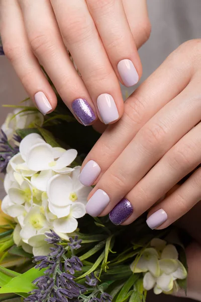 Manicure ordinata viola su mani femminili su sfondo di fiori. Progettazione unghie — Foto Stock