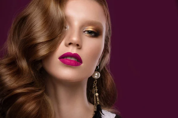 Mooie redhair model: krullen, lichte gouden make-up, sieraden en rode lippen. Het gezicht van de schoonheid. — Stockfoto