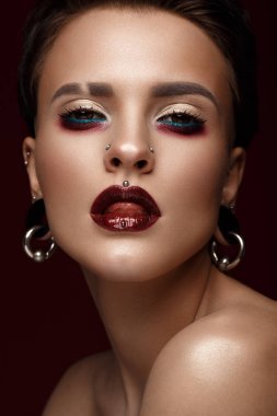 Sanat yaratıcı makyaj ve küpe yüzünde güzel bir kızla.